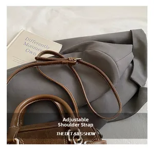 Close-up of the adjustable shoulder strap and silver metal buckle on a Boston bag