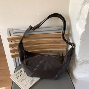 Détail du sac hobo en daim gris anthracite avec coutures blanches contrastées et fermeture éclair
