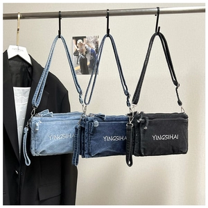 Detailed view of three-color denim crossbody bags with adjustable straps and zipper pockets