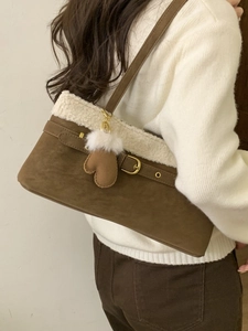 Brown faux shearling shoulder bag for women worn by a model in a cozy winter style