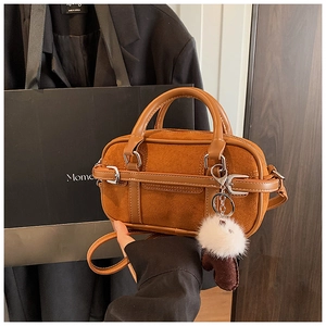 Detail of vintage brown Boston bag featuring suede patchwork and plush charm