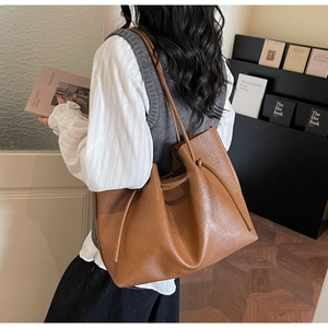 Detailed view of caramel tote bag with drawstring knots on model in minimalist interior