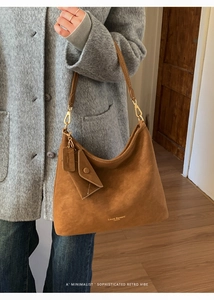 Detailed texture of brown suede hobo bag with gold hardware and small pouch attachment
