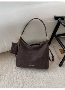 Detail of vintage brown textured leather hobo bag with mini pouch and gold hardware