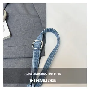 Macro view of adjustable denim shoulder strap with silver square metal buckle details