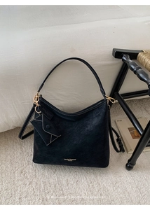 Detail of black matte leather hobo bag with gold metal buckle and mini envelope charm