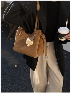 Chic brown suede tote bag styled with a minimalist black blazer for a casual commute look