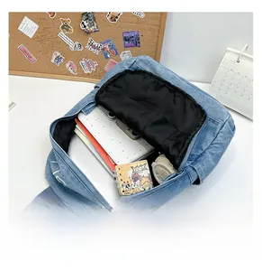Internal capacity of denim backpack showing space for A4 books and electronic devices