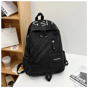 Detail of black denim backpack with three parallel diagonal zippers and vintage aesthetic