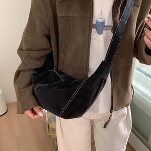 Détail du sac demi-lune en suédine noire avec surpiqûres blanches contrastées
