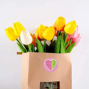 Pink heart sticker on kraft bag with tulips for Happy Valentine's Day gift decoration