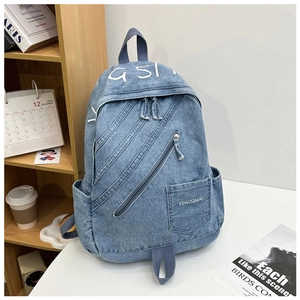 Macro shot of light blue denim backpack with detailed side pocket and white G51 branding