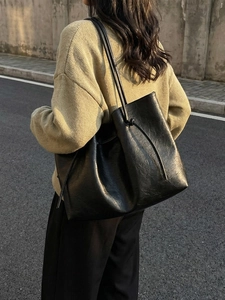 Minimalist black oversized leather tote bag with knotted straps for women's daily commute