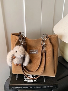 Retro brown tote bag with metal chains and cute plush rabbit pendant in daily setting