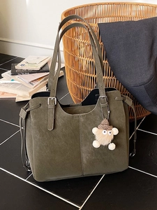 Chic dark green oversized tote bag in faux suede with adjustable straps and plush charm