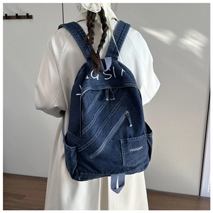 Macro shot of dark blue denim backpack texture with diagonal zipper and white lettering