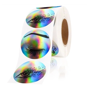 Macro view of holographic rainbow stickers with hand-drawn eyelash illustrations for packaging
