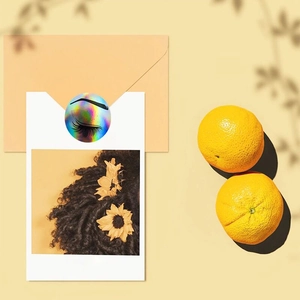 Holographic rainbow thank you sticker with eyelash design used for sealing orange envelopes