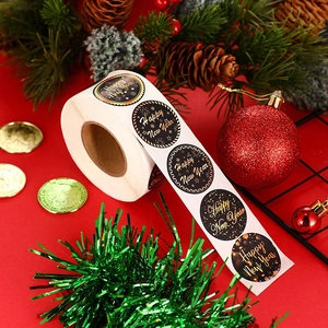 Roll of round Happy New Year gift stickers with gold text on black for holiday packaging