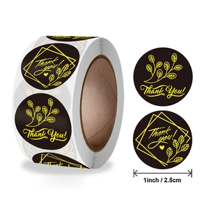 Gold foil Thank You stickers on a black roll for gift sealing, 1 inch round design
