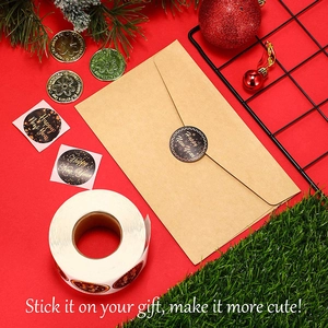 Roll of black and gold Happy New Year stickers on envelopes with festive decor