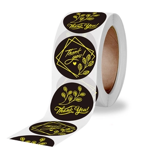 Roll of black and gold Thank You stickers with floral patterns for gift packaging