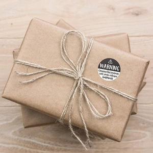 Warning extreme happiness black round labels on kraft gift box with jute rope
