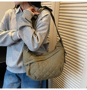 Detailed view of an army green quilted crossbody bag worn by a model in casual style