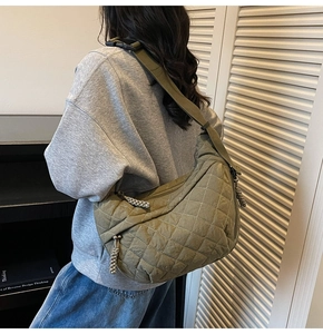 Detail of army green quilted crossbody bag featuring rhombic stitching and nylon strap