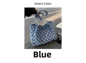 Detailed macro of blue checkerboard denim tote bag with silver chain handle outdoors