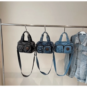 Detail view of denim crossbody bags in three shades with functional front pockets