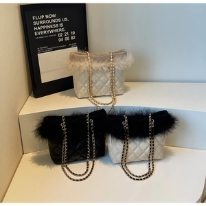 Detailed view of quilted chain tote bags featuring faux fur and feather trim accents