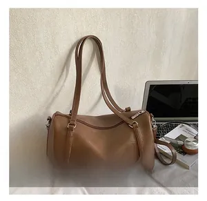 Gros plan d'un sac Boston vintage marron avec ordinateur portable et casque sur bureau