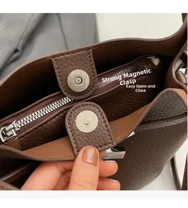 Detail view of leather bucket bag interior with magnetic buckle and zipper pocket