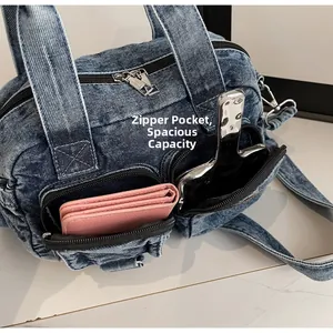 Detailed view of spacious front zipper pockets on this blue denim canvas crossbody bag