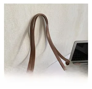 Détail du sac cabas marron vintage montrant la texture du cuir et les coutures solides