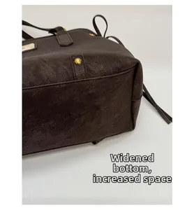 Detail of widened bottom and textured leather of the large dark brown tote bag