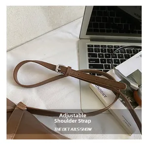 Détail de la bandoulière réglable en cuir marron avec boucle en métal argenté