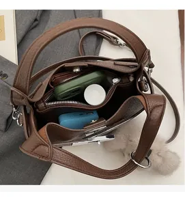 Spacious interior of brown pebbled leather bucket bag showing compartments and storage