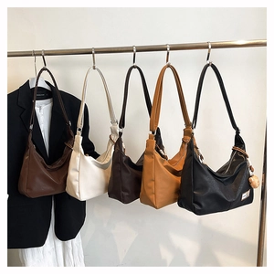 Detail of vintage Hobo tote bags in five colors hanging with a suit and skirt