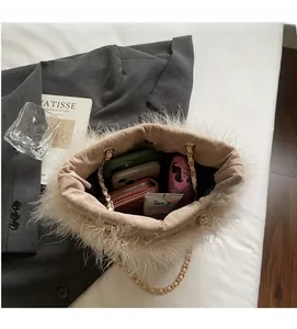 Detail view of the open beige feather bag showing spacious interior and golden chain strap