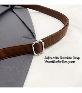 Detail of adjustable brown leather strap with silver square buckle on a grey tote bag