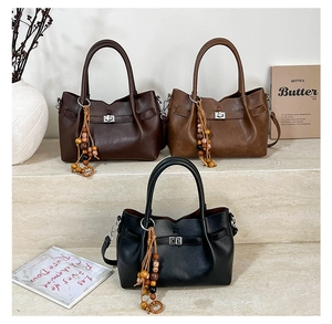 Detailed close-up of retro leather tote bags in dark brown, tan, and black with metal locks