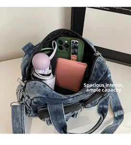 Spacious interior of denim crossbody bag showing storage for phone, wallet and umbrella
