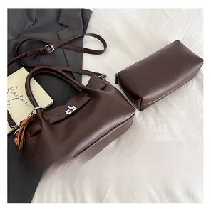 Detail view of a chocolate brown bucket bag with swivel lock, wooden bead and inner pouch
