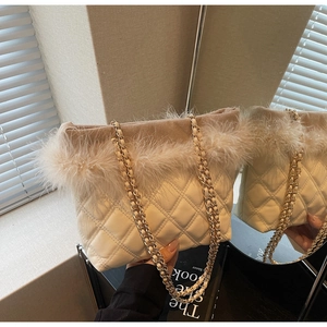 Dettaglio borsa shopper trapuntata bianca con bordo in finta pelliccia e catena oro