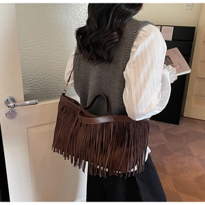 Détail d'un grand sac cabas vintage en daim marron avec de longues franges denses