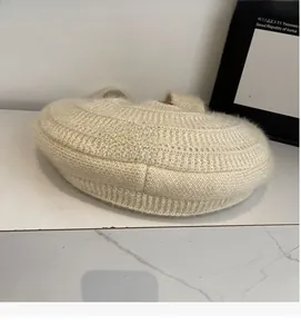 Close-up of soft cream-colored plush knit texture on a large capacity hobo shoulder bag