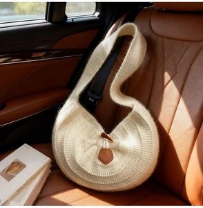 Détail du sac hobo en maille crème avec texture douce et boucle en corne élégante