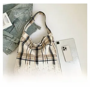 Detailed flat lay of a vintage striped canvas tote bag with British plaid pattern